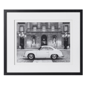 The black & white photo of a white classic hard top Porsche 356 in a Roman setting. Black framing in passe partout. Meaurements: Dimensions: H:48 W:58 cm.